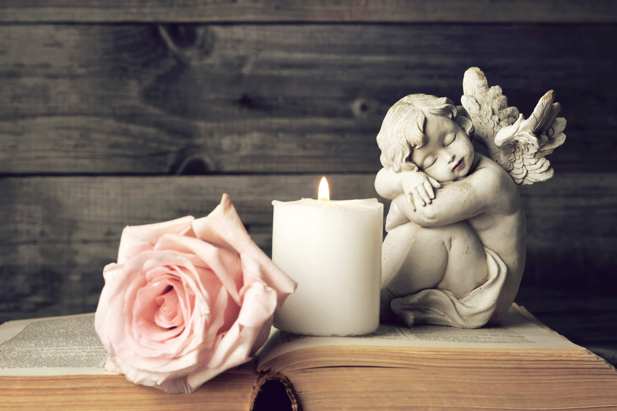 estatua de ángulo con rosa y vela