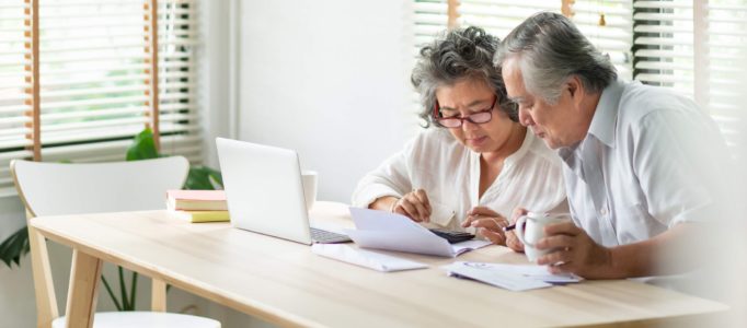 Pareja de ancianos jubilados mirando a través de impuestos