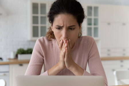 señora leyendo advertencia de estafa de impuestos en la computadora