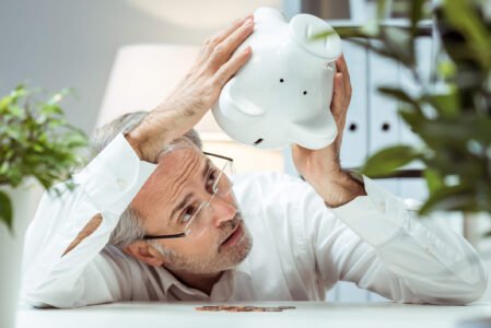 man shaking piggy bank because he can't pay taxes