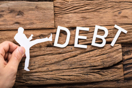 hombre de papel pateando la deuda - cancelando la deuda tributaria