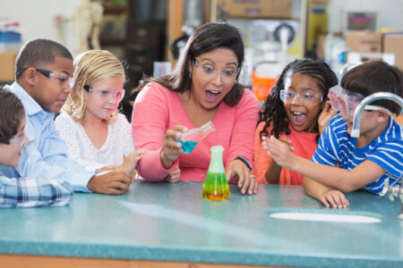 teacher showing kids science project - tax deductions for teachers