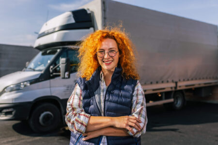 female trucker standing by rig
